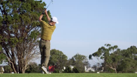 golf player hitting the ball with his club