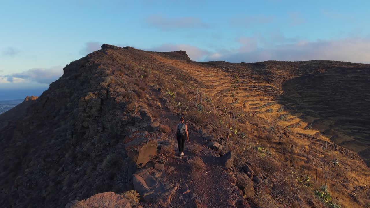 Tourist walking on mountain path at sunset in Gran Canaria, Temisas