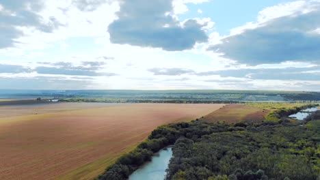vista aérea de un paisaje rural con campos, río y bosque