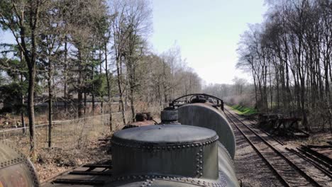 rusty train tank cars in a forest