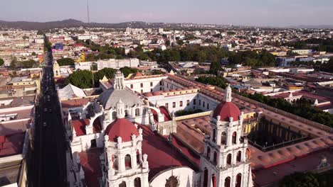 Aerial-drone-panoramic-backward-shot-over-a-historical-church-in-Puebla,-Mexico-at-daytime-ideal-for-history-and-travel-enthusiasts-touristic-important-points-of-mexican-spots