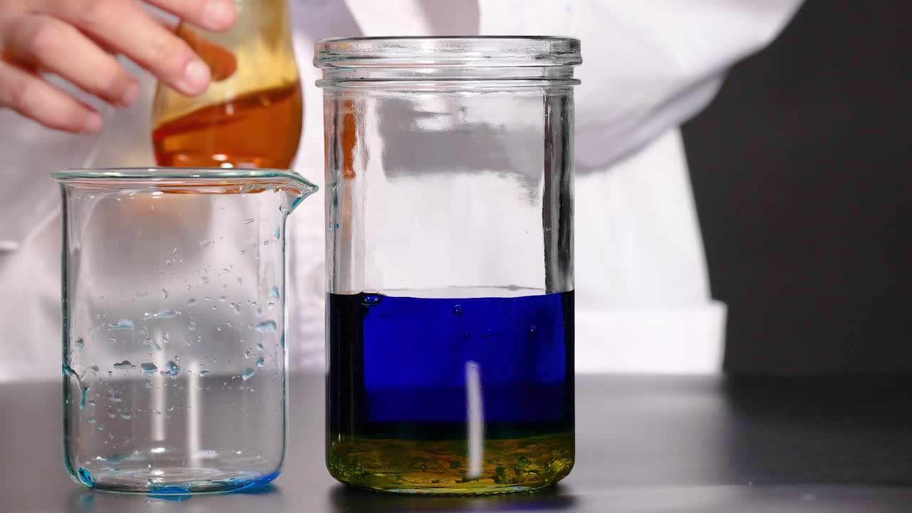 un científico lleva a cabo una vibrante reacción química, mostrando cambios de color en los líquidos dentro de vasos de vidrio bajo iluminación controlada
