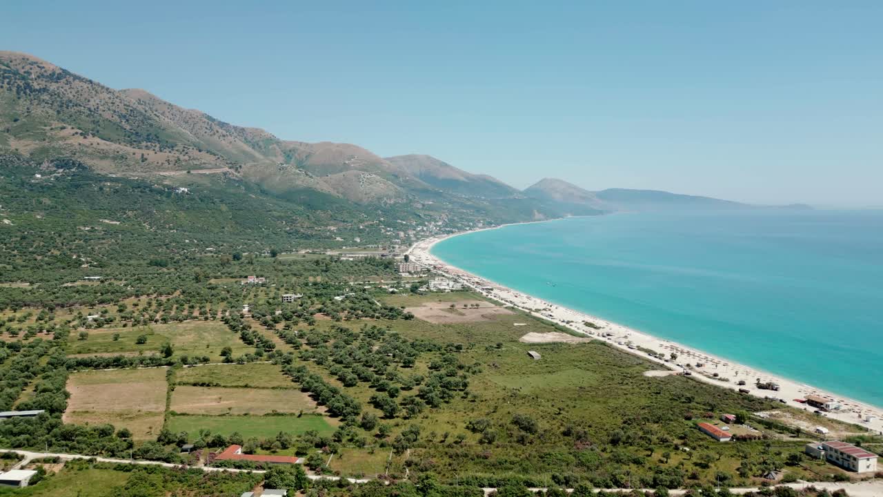 Albania, drone view of the beach, emerald waters of the Ionian Sea, and the Ceraunian Mountains