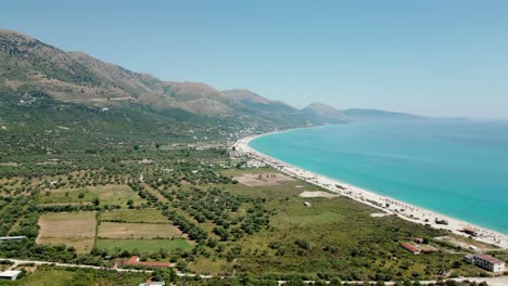 albania, drone view of the beach, emerald waters of the ionian sea, and the ceraunian mountains