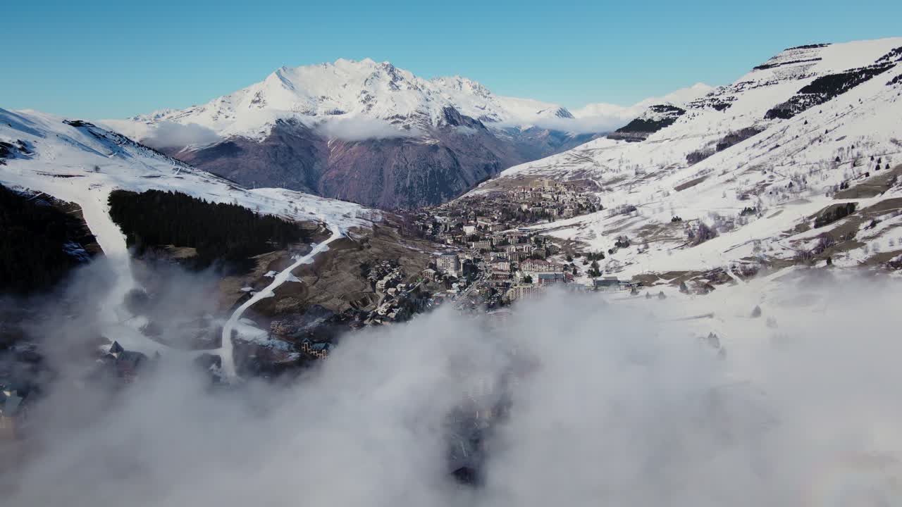 video de un avión no tripulado volando a través de las nubes hacia una cordillera nevada