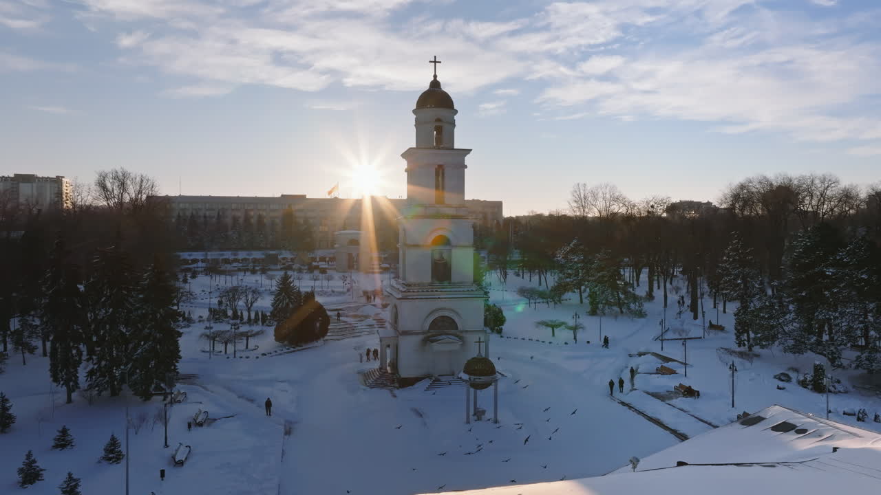 Aerial drone view of the Bell tower of the Metropolitan Cathedral of Christ's Nativity. City center covered in snow at sunset in Chisinau, Moldova