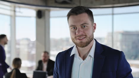 portrait of a smiling entrepreneur standing in the office. close up. active teamwork at the desk at background.