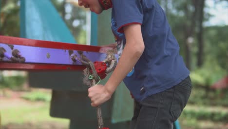 Male-child-climbing-rope-ladder-at-playground-closeup