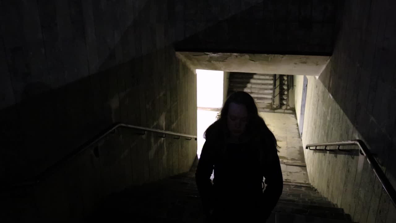 Girl walking out from the underground passage in the night