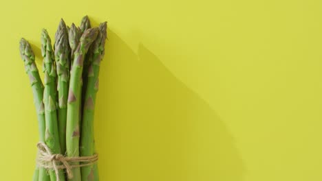 video of bundle of fresh asparagus with copy space over green background