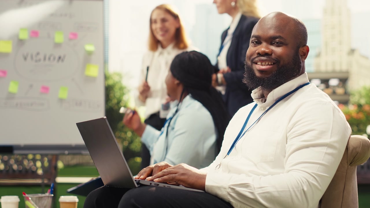 Professionel afroamerikansk mand arbejder på bærbar computer til kontormøde