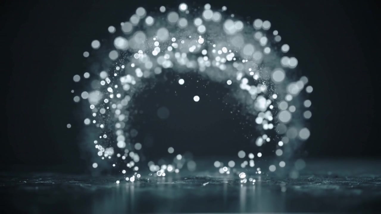 Goccioline luminose che si innalzano dal pavimento formando un anello circolare per creare un bagliore in uno studio, con il pavimento bagnato.