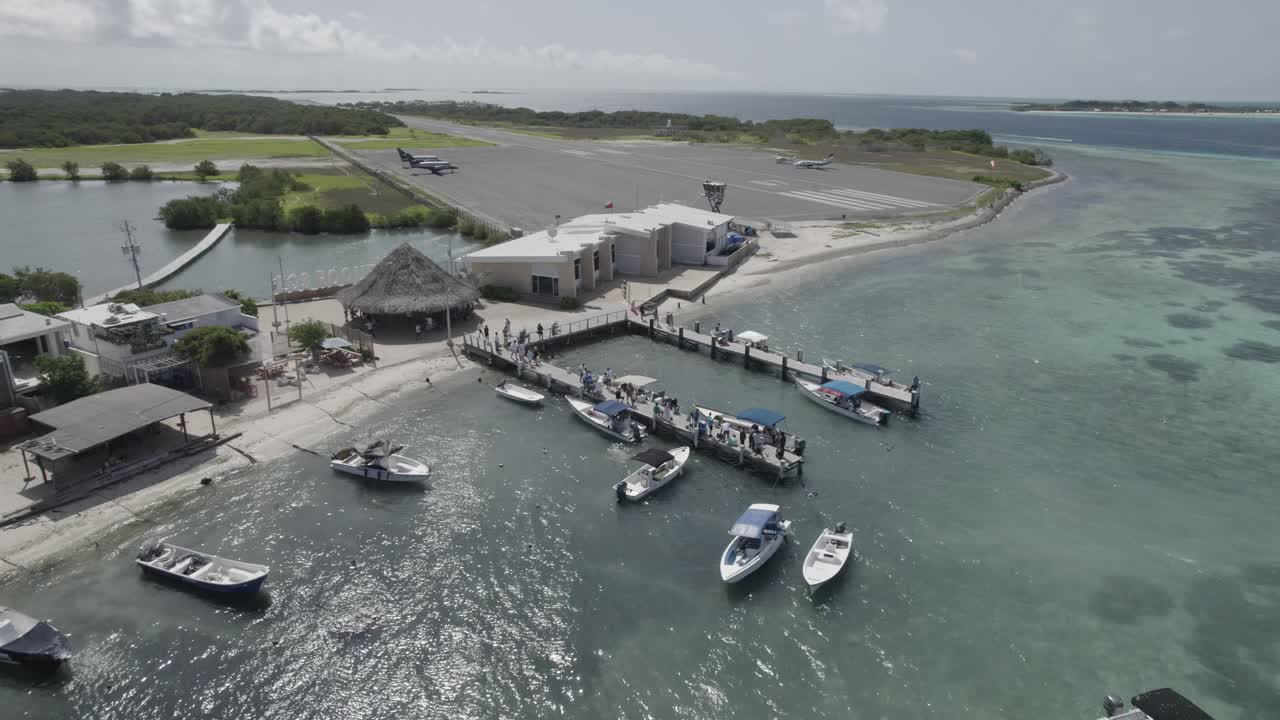 Aerial view of an island airport with boats and a dock