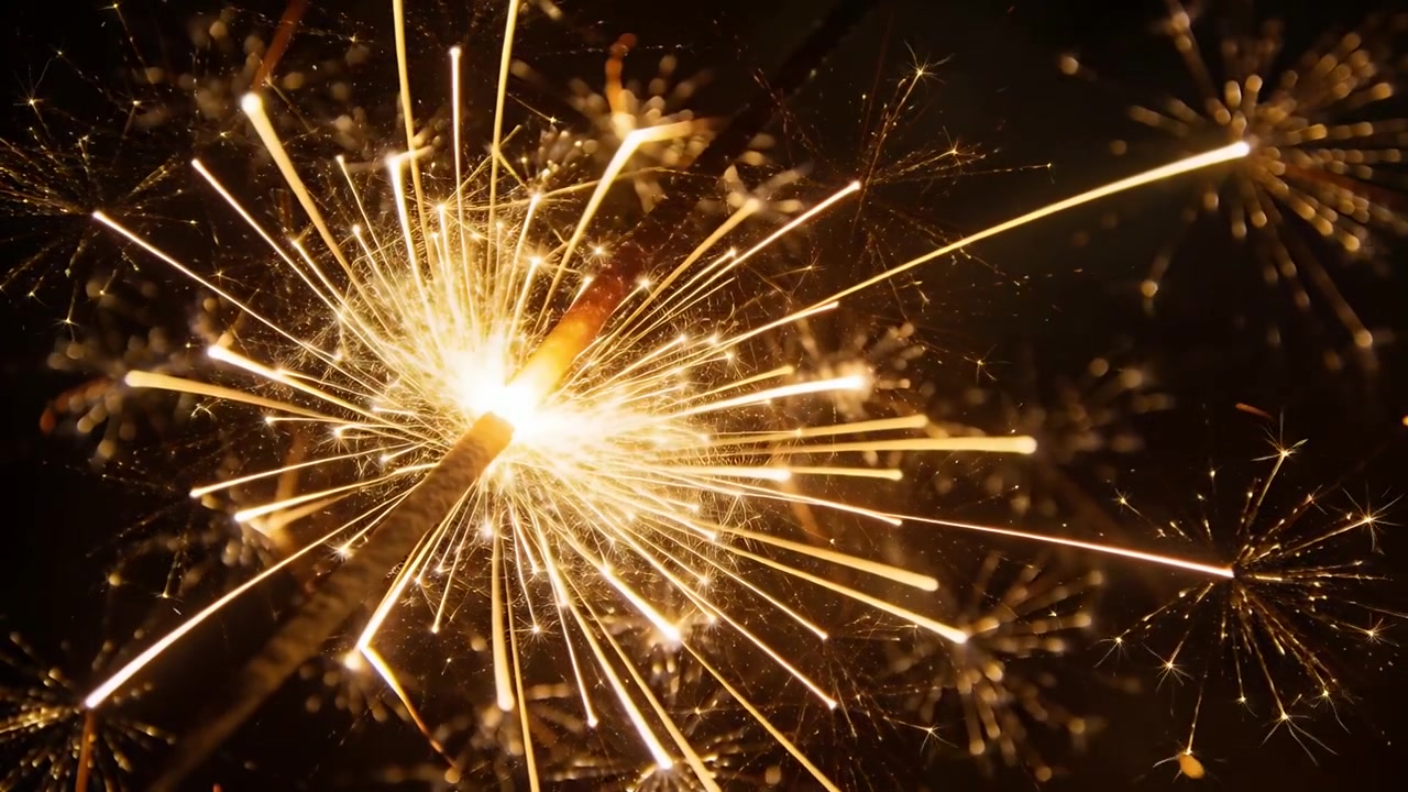 Una bacchetta luminosa a mano che emette scintille radiali e punte a stella, mentre il metallo brucia contro lo sfondo nero.