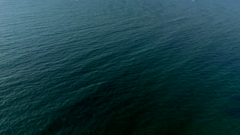 aerial view of deep ocean water, showing calm rippling patterns across a vast expanse