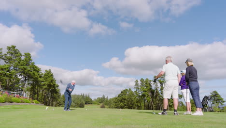 golf players playing golf and knocking golf ball out on golf course