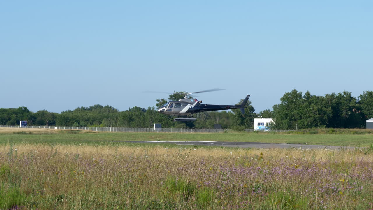 헬리콥터는 화창한 날 헬기 착륙장에서 떠다니다가 이륙합니다.