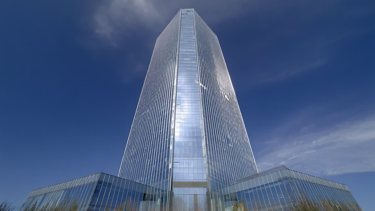 Una vista mozzafiato di un grattacielo moderno contro un cielo azzurro limpido, che mostra facciate in vetro ed eleganza architettonica nel cuore della città