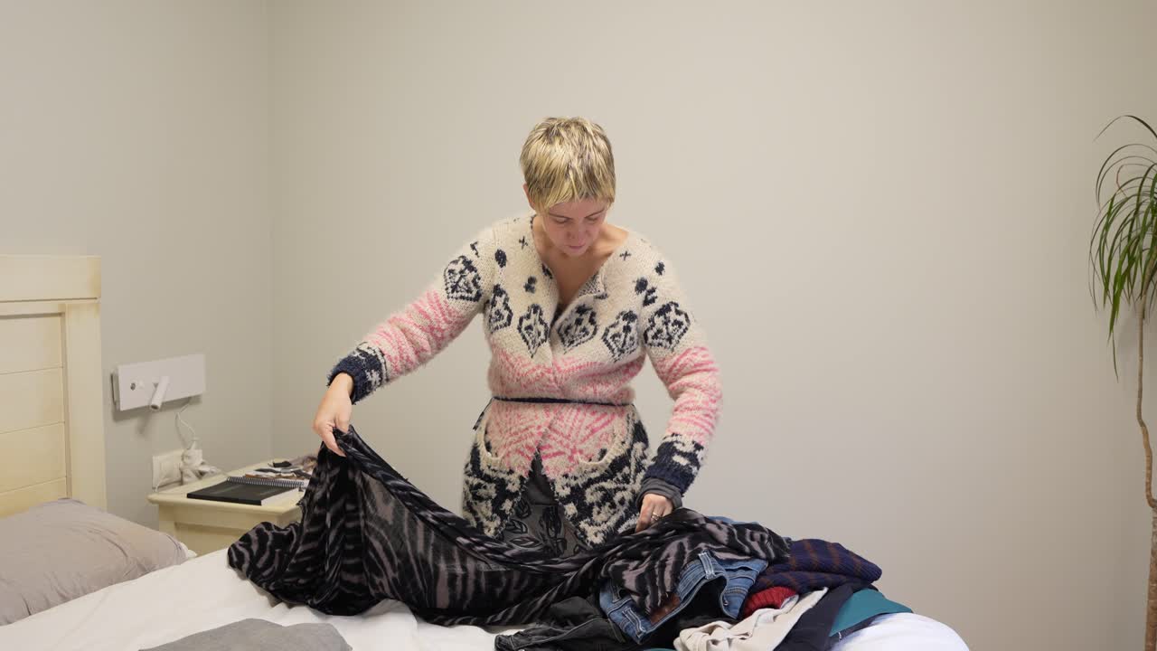 Woman folding clothes in the bedroom