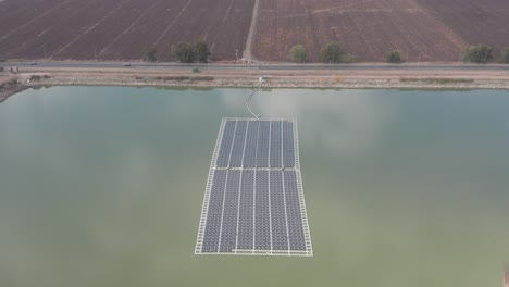 aerial view of floating solar panels in a small pond