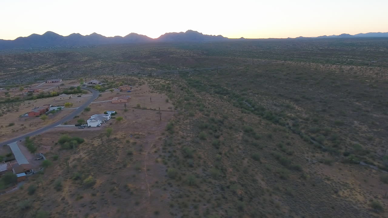 Ripresa panoramica di un paesino nel mezzo del deserto con montagne sullo sfondo al tramonto, situato vicino a Flagstaff, Arizona.