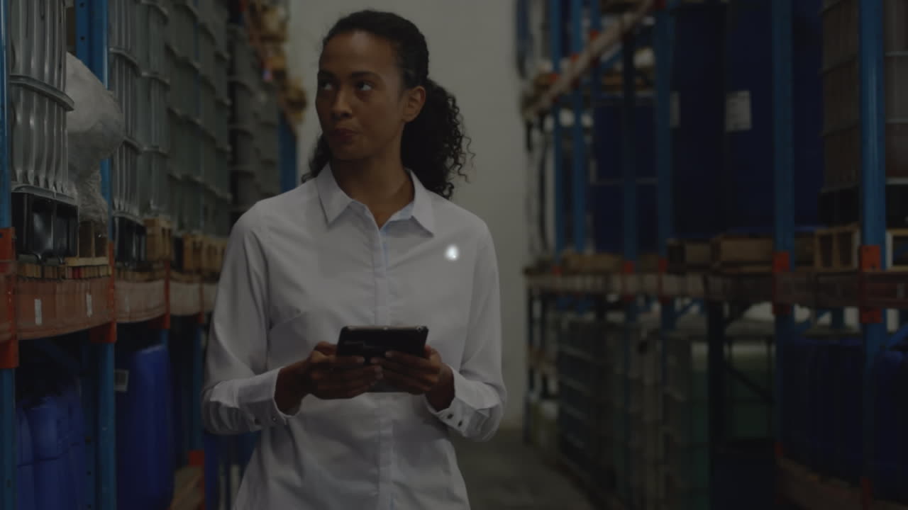 Animation of connected icons, abstract shape, african american woman checking inventory in warehouse