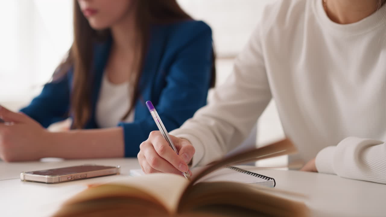 젊은 여성 학생들은 수업에서 공부합니다. 젊은 여성들은 현대 기술을 사용하여 책상에서 신용을 준비합니다. 대학에서 동료를 공동으로 훈련시니다.