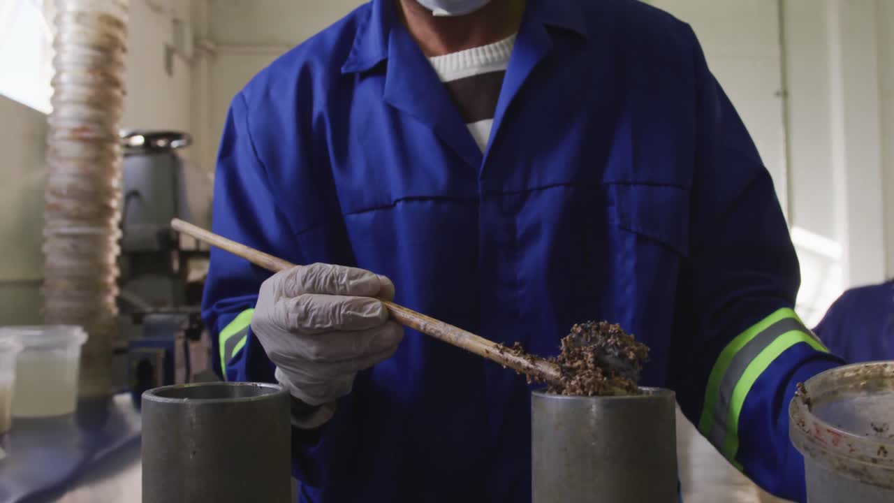 mann gemischter rasse, der in einer fabrik arbeitet