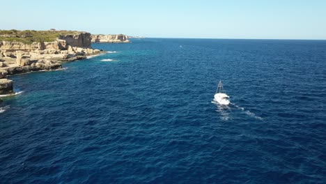 a boat in majorca with sharp cliffs on the side