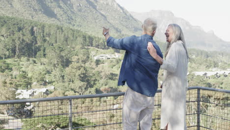 Feliz-Pareja-Caucásica-De-Mediana-Edad-Hablando-En-Una-Terraza-En-Las-Montañas,-Cámara-Lenta