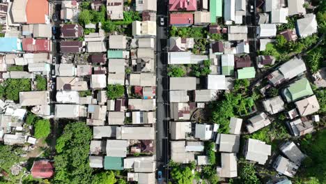 narrow urban street lined with dense, low-roofed houses in a tightly packed residential neighborhood