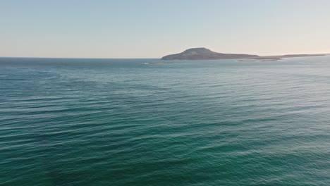 Drone-wide-angle-shot-of-approaching-island-at-pacific-ocean,-dolly-in