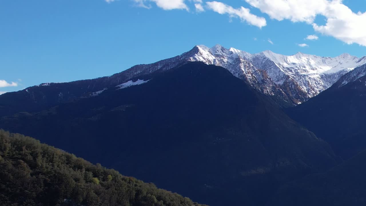 Aerial view of Italy's Alps with green hills and snowy peaks