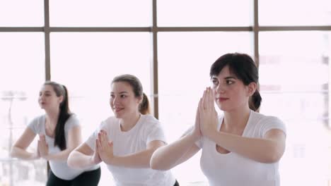 women doing stretching exercises in a modern gym with an instructor