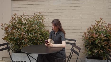 woman using smartphone in outdoor cafe