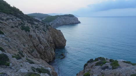 time lapse captures cliffs near sea coast during sun rise over mountain range