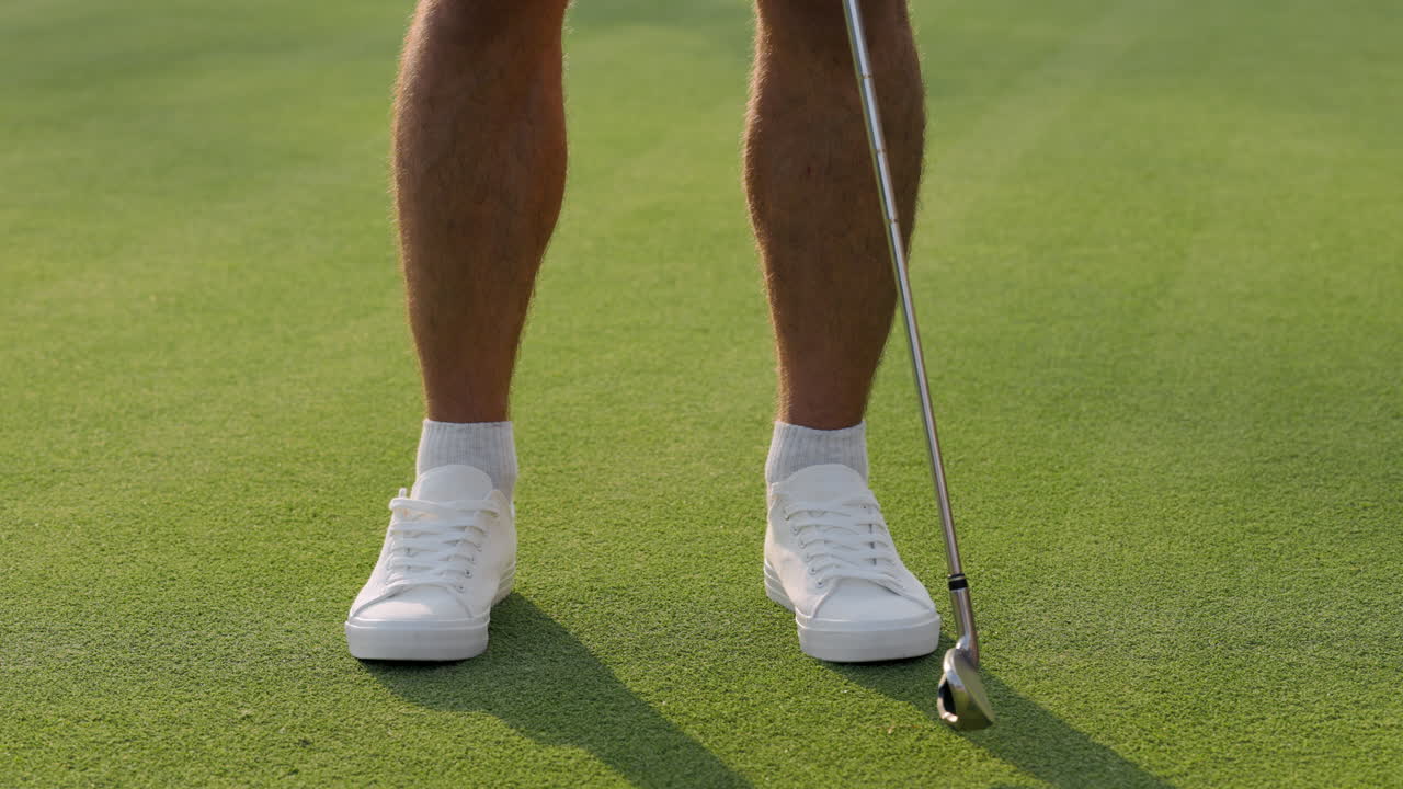 Person preparing to putt golf ball