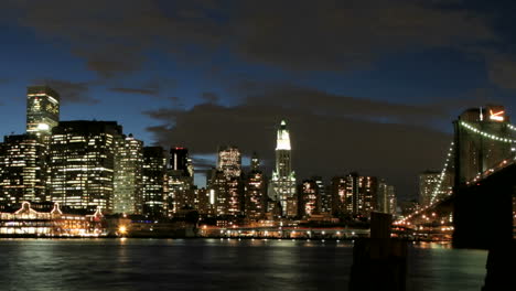 Langsamer-Schwenk-Einer-Zeitrafferansicht-Der-Brooklyn-Bridge-Und-Der-Skyline-Von-New-York-Von-Der-Goldenen-Stunde-Bis-Zur-Nacht