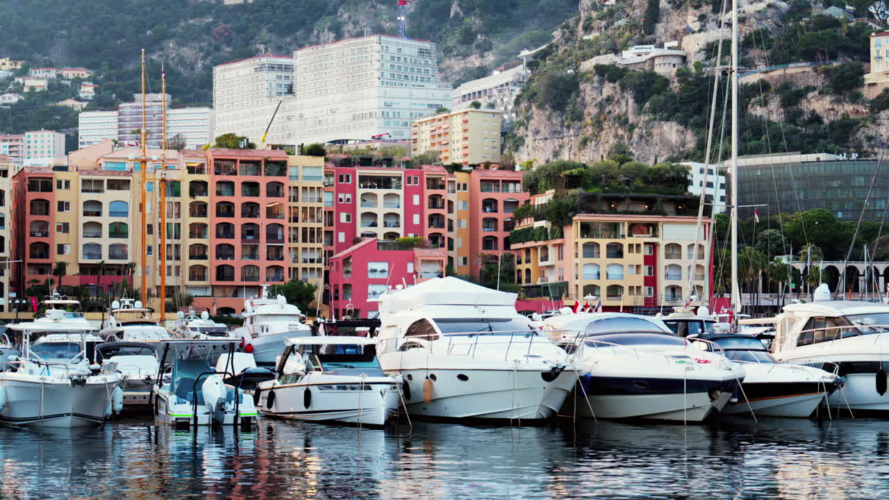 View of boats docked in the Monaco Marina with the skyline of the city on the background