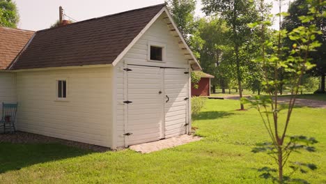 panning-shot-of-the-exterior-of-an-old-white-wooden-building-on-a-sunny-day