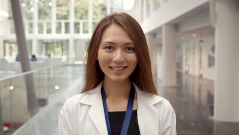 portrait of smiling female doctor in lobby of hospital