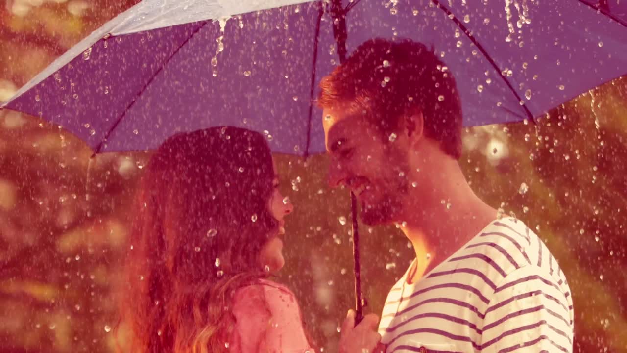 비가 내리는 동안 공원에서 포옹하는 행복한 커플