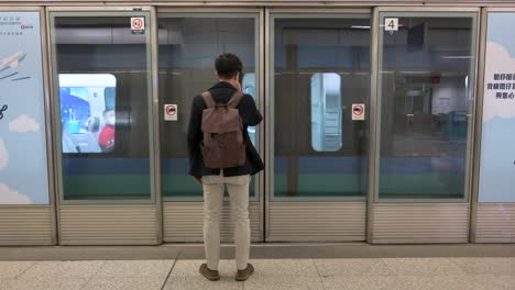 Un-Viajero-Entra-En-Un-Tren-Del-Aeropuerto-En-Una-Estación-De-Metro-En-Hong-Kong