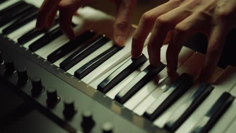 man hands playing piano in studio. unrecognizable person making music in hall.