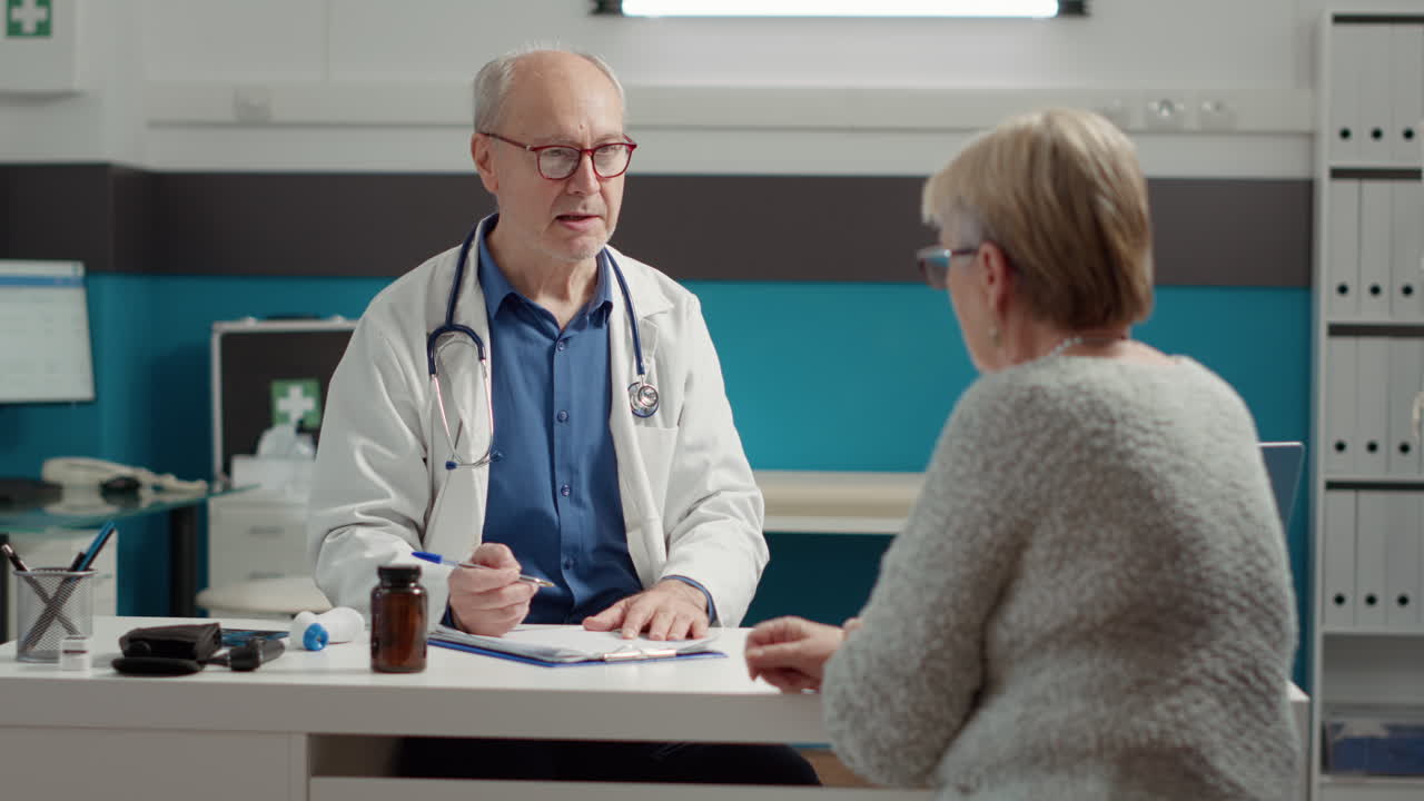 Male specialist writing health care report about senior patient