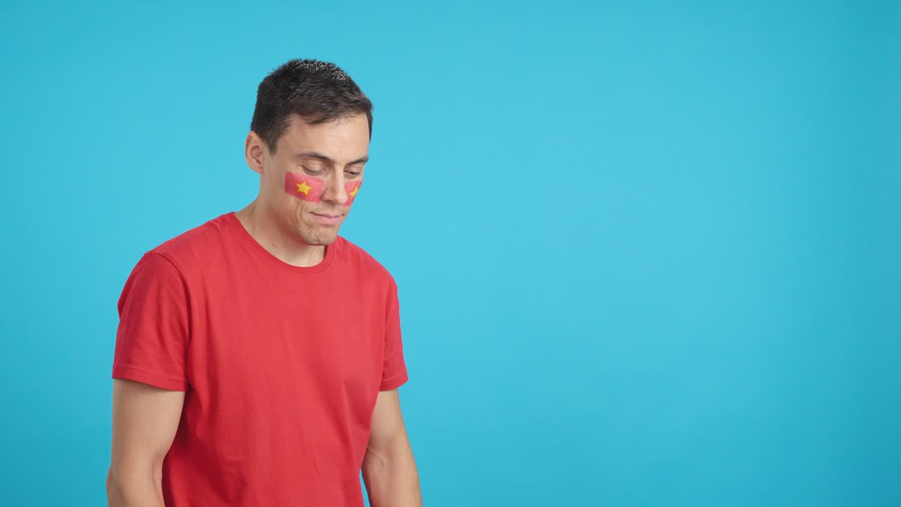 Happy man with vietnamese flag painted on face looking away