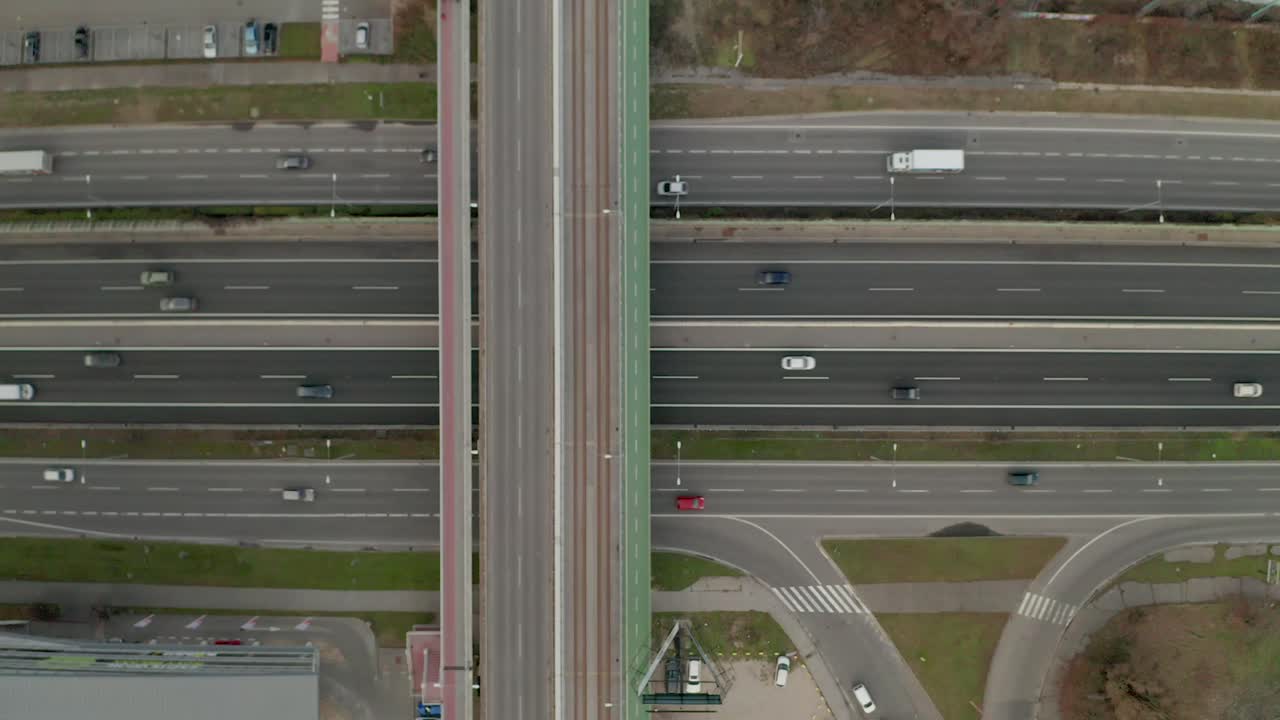 Aerial ascending drone footage of a highway with moving cars.