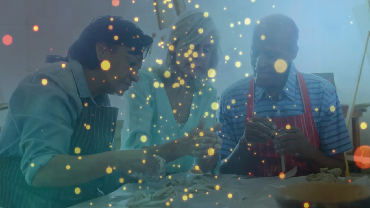 アートワークショップで、リードインストラクターがピンチ成形を実演し、学習者が粘土のひもを転がし始める