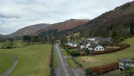 Cinematic-cumbrian-aerial-lndscape,-Aerial-view-of-motorbikes-moving-down-a-country-road-in-Grasmere