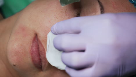 cleaning the skin imperfections with ultrasonic scrubber. beautician moves the cosmetic device around the female nostrils. extreme close up.